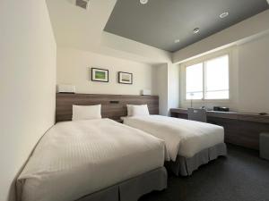 um quarto com 2 camas e uma janela em Best Western Sapporo Odori Koen em Sapporo