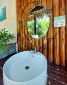 ein Badezimmer mit einem weißen Waschbecken und einem Spiegel in der Unterkunft Avila's Horizon Dive Resort Malapascua in Malapascua