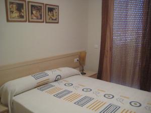 Habitación pequeña con cama con colcha. en Apartamento Illa Mar, en Sant Carles de la Ràpita