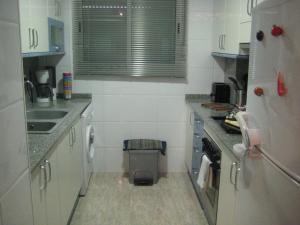 een kleine keuken met witte kasten en een spoelbak bij Apartamento Illa Mar in Sant Carles de la Ràpita