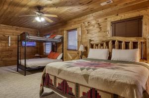 a bedroom with a bunk bed in a log cabin at Bridgewood Cabin- New Listing - Hot Tub, Pool Table, Free Attraction Tickets in Pigeon Forge