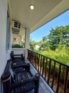 a porch with a bench on a balcony at Avila's Horizon Dive Resort Malapascua in Malapascua Island