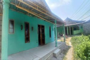 Casa verde con porche y edificio en SPOT ON 93324 Hadi Homestay Syariah en Sleman