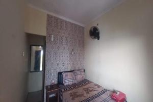 Llit o llits en una habitació de SPOT ON 93324 Hadi Homestay Syariah