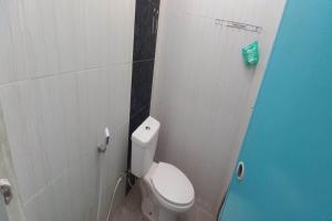 - une salle de bains avec des toilettes blanches dans une cabine dans l'établissement SPOT ON 93324 Hadi Homestay Syariah, à Sleman
