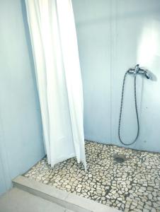 een douche met een wit douchegordijn in de badkamer bij La Pause Mafate in La Possession