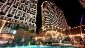 un groupe de grands bâtiments la nuit avec une piscine dans l'établissement APEC MANDALA KOLYA Building D, à Phan Thiết