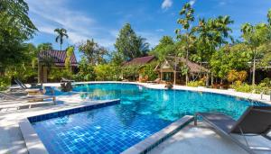 a swimming pool in a resort with blue water at Baan Suan Villas Resort in Ban Suan