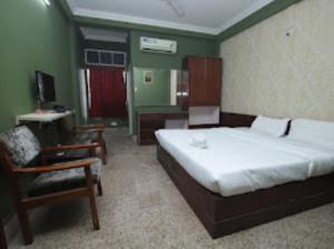 Schlafzimmer mit einem Bett, einem Schreibtisch und einem Stuhl in der Unterkunft HOTEL EAST INN DIMAPUR in Dimapur
