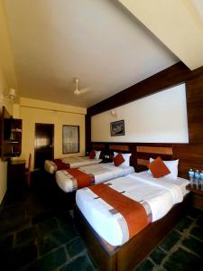 a row of three beds in a hotel room at Hotel Kunja in Pokhara