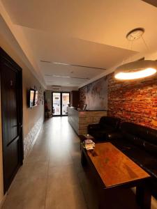 a living room with a couch and a brick wall at Loft Host Yerevan in Yerevan