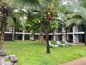 dos palmeras frente a un edificio con bancos en VANA Wellness Resort, 