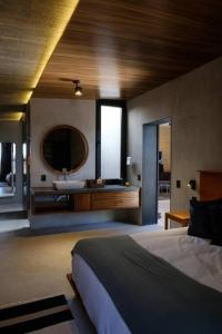 - une chambre avec un lit, un lavabo et un miroir dans l'établissement Viñedo Bodega 1881, à Santa Ana