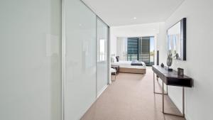 a living room with white walls and a large mirror at Bridgepoint 502 in Mandurah