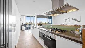 a kitchen with white counters and a stove top oven at Bridgepoint 502 in Mandurah