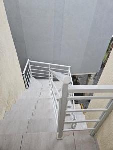 Una escalera con barandilla blanca en un edificio. en Casa de praia em Piratininga, en Niterói 1 foto más