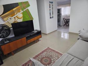 Una sala de estar con televisión y un sofá. en Casa de praia em Piratininga, en Niterói