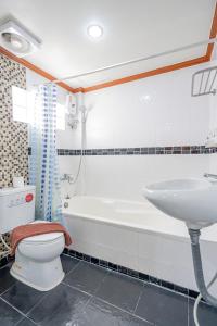 La salle de bains est pourvue d'une baignoire, de toilettes et d'un lavabo. dans l'établissement Patong Social Hotel & Restaurant, à Patong Beach