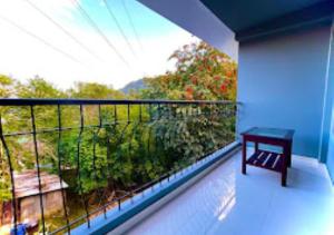 einen Balkon mit einem Tisch und Gartenblick in der Unterkunft La Colline Resort Nagaland in Kohīma