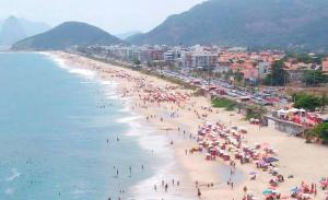 un grupo de personas en una playa con sombrillas en Casa de praia em Piratininga, en Niterói