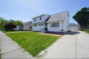 a white house with a yard and a driveway at Two Bedroom Apartment In Cheektowaga in Cheektowaga