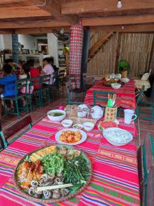 einen Tisch mit Teller mit Speisen darüber in der Unterkunft LePont Mu Waterfall Bungalow in Hòa Bình