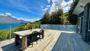 a wooden deck with a table and chairs on it at Te Wai • Luxe @ The Lake • in Queenstown