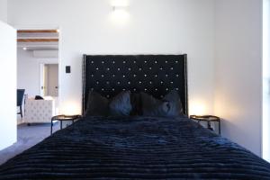 a bedroom with a large bed with a black headboard at Te Wai • Luxe @ The Lake • in Queenstown
