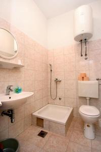 La salle de bains est pourvue de toilettes, d'un lavabo et d'une douche. dans l'établissement Apartments Sunny - quiet and relaxing, à Makarska