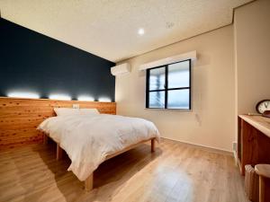 Un dormitorio con una cama grande y una ventana en Hotel Ishigaki and Chikonkiya, en Ishigaki Island