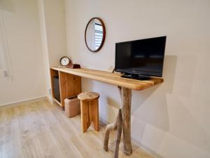 a desk with a tv on a wall with a mirror at Hotel Ishigaki and Chikonkiya in Ishigaki Island