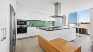 a kitchen with white cabinets and a counter top at Seapoint 102 in Mandurah