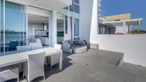 a patio with a white table and chairs on a building at Seapoint 102 in Mandurah