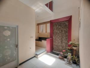 a room with a kitchen with a red wall at Mulia Homestay Pasuruan 