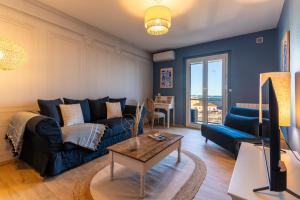 un soggiorno con un divano blu e un tavolo di La Petite Venise a Sète
