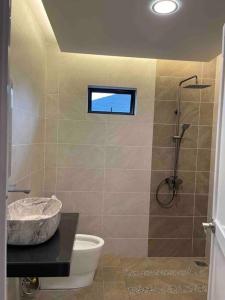 a bathroom with a shower with a toilet and a sink at Welcome to Sarmax Homestay in Kuching