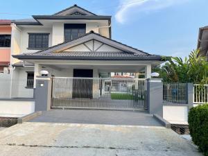 a white house with a gate in front of it at Welcome to Sarmax Homestay in Kuching