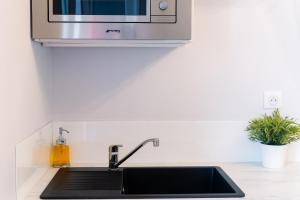 una cucina con lavello e microonde di La Petite Venise a Sète Altre 8 foto