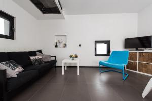 a living room with a black couch and a blue chair at Villa Gordan - Happy Rentals in Dragove