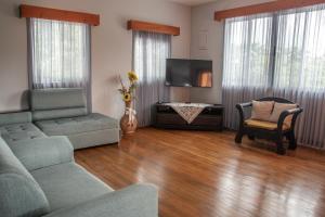 a living room with a couch and a tv at Organic Garden in San José
