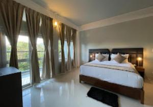 ein Schlafzimmer mit einem Bett und einem großen Fenster in der Unterkunft La Colline Resort Nagaland in Kohīma