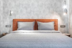 1 cama con cabecero de madera y 2 almohadas en Apart Hotel Colibri en Almaty