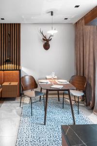 a dining room with a table and chairs on a rug at Apart Hotel Colibri in Almaty