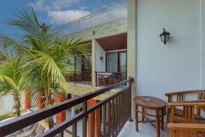 een balkon met een tafel en een stoel bij Sedana Cottage in Canggu