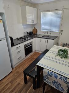 a kitchen with white cabinets and a table with a table sidx sidx at Family Oasis in Adelaide in Bowden