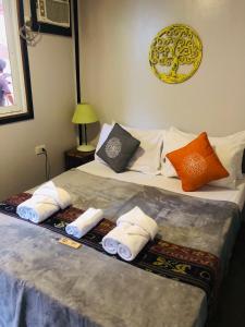 1 dormitorio con 1 cama con toallas en Keira Backpackers, en El Nido