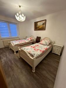 a bedroom with two beds and a chandelier at Ferienwohnung 24 Unten Rechts 3 Zimmer in Lathen