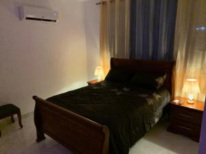 a bedroom with a bed and two lamps on tables at Villa de Lujo con Picsina Privada in San Pedro de Macorís +17 photos