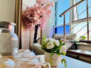 a table with a vase with pink flowers on it at Beijing Lesiure Aparment - 200M from Exit D of Line 6 in CBD in Beijing