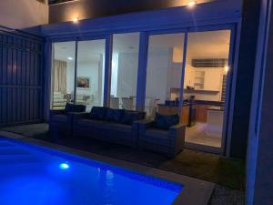a living room with a couch and a swimming pool at Villa de Lujo con Picsina Privada in San Pedro de Macorís
